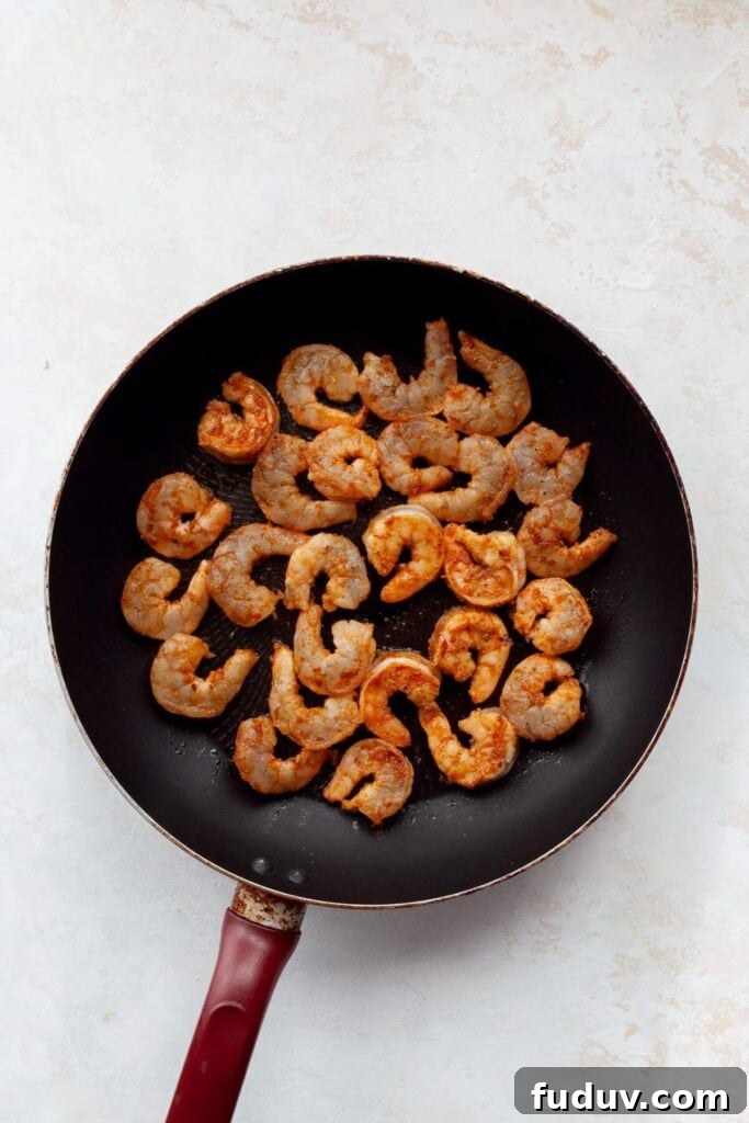 cooking shrimp in a pan with olive oil