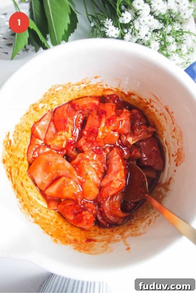 Sticky Gochujang Chicken Recipe: Sweet Spicy Korean Glaze 4 Chicken tossed through gochujang marinade in bowl.