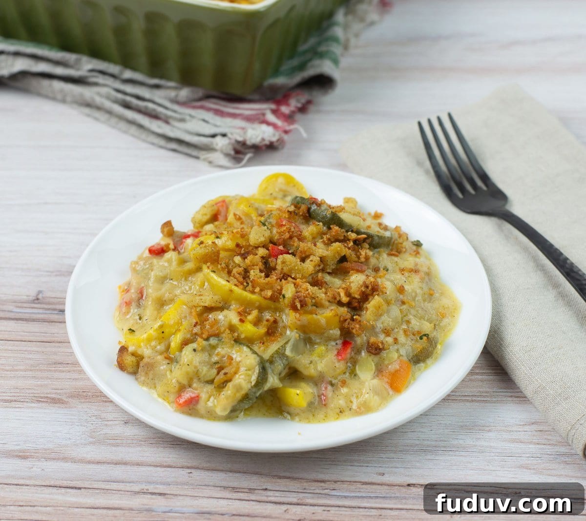 Yellow squash and zucchini casserole with stuffing topping on a white plate.