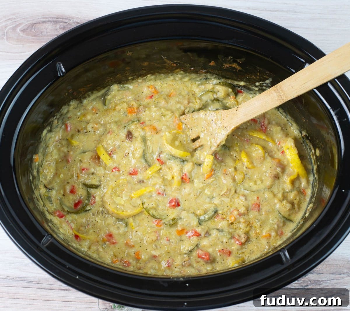 Tender yellow squash casserole in the crock pot after slow cooking.