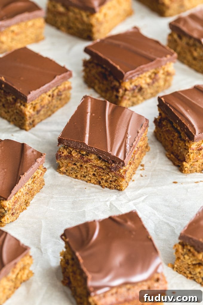 Banana snack cake cut into squares and arranged on parchment paper.