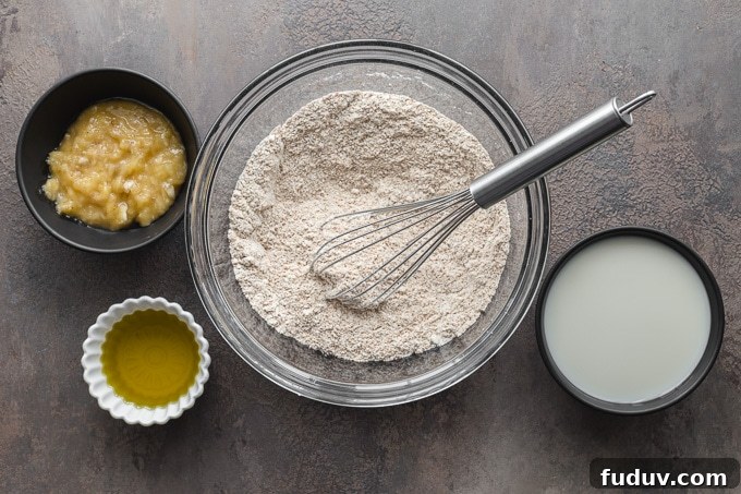 Dry ingredients being whisked together in a glass bowl.
