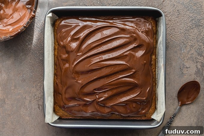 Cake topped with melted chocolate and almond butter.