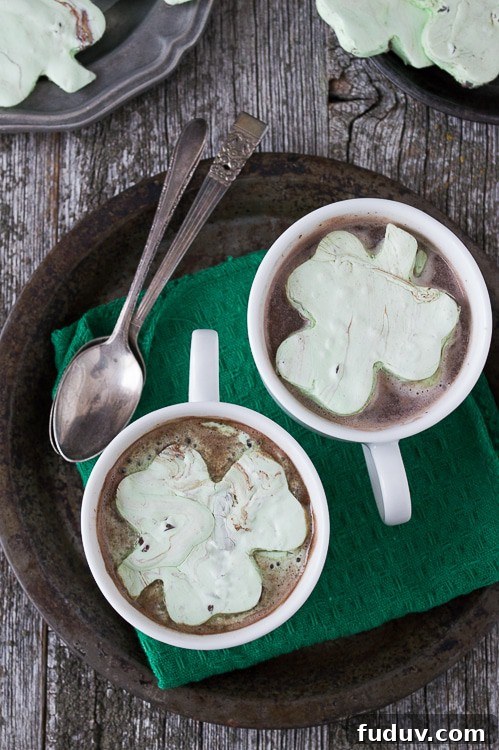 Mint Chocolate Chip Shamrock Marshmallows - a fun homemade marshmallow recipe for St. Patrick’s Day. These are so fun! Mint Chocolate Chip Shamrock Marshmallows in two Cups of Hot Cocoa