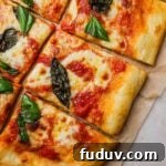 Homemade margherita pizza topped with authentic pizza sauce, mozzarella, and basil.