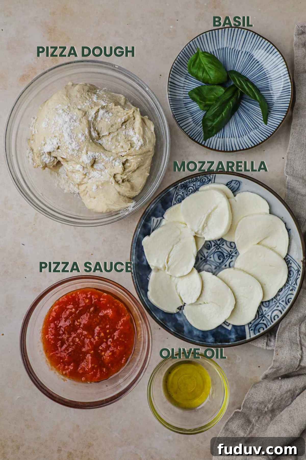 Ingredients to make homemade margherita pizza: pizza dough, basil, mozzarella, pizza sauce, olive oil.