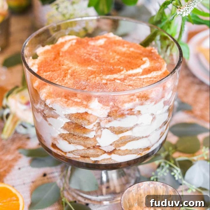 Tiramisu in a glass trifle bowl with green and white flowers