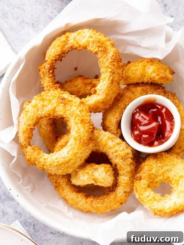 Bowl of Air Fryer Onion Rings served with ketchup.