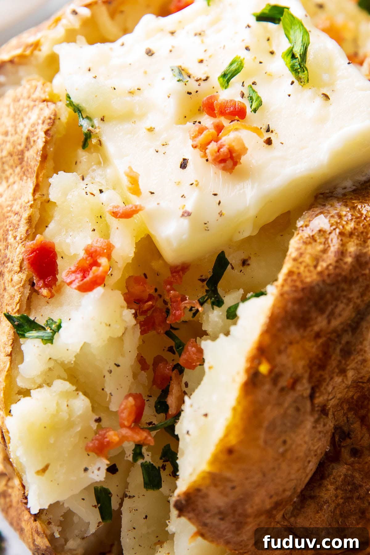 Close up of baked potato in air fryer to show soft center and crisp skin
