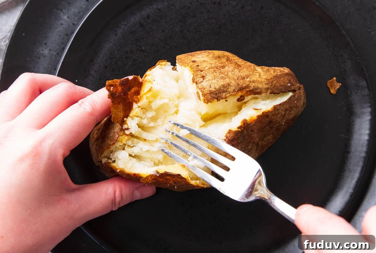 A showing how to split one open - using a fork to mash and fluff up the center