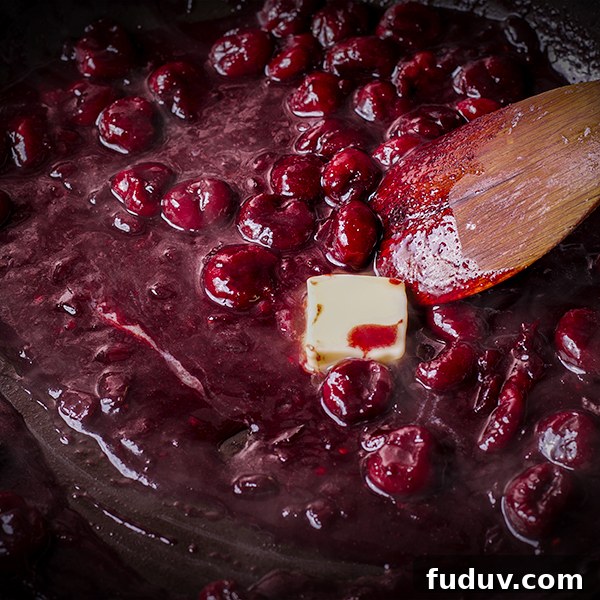 Stirring butter into red wine cherry sauce.