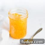 open jar of jam with a spoonful next to it