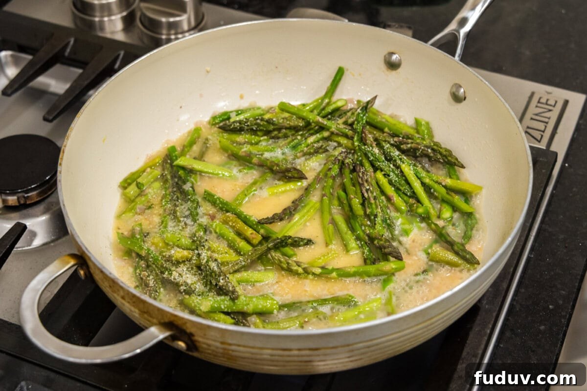 asparagus added to melted butter mixture in skillet