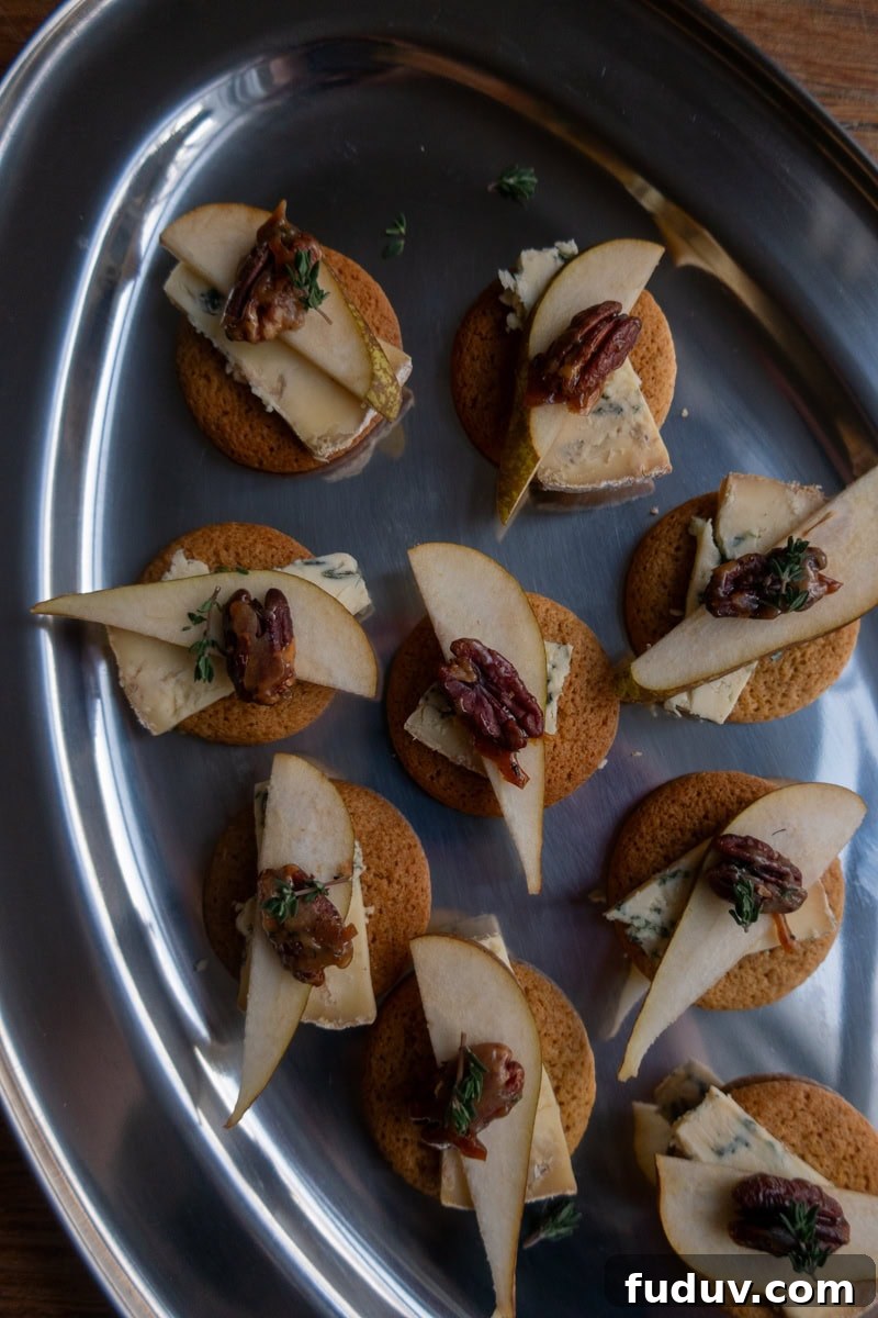 Ginger Nut Canapés with Stilton and Pear 2 Ginger biscuits topped with slices of stilton and pear, garnished with candied pecans - Georgie Mullen