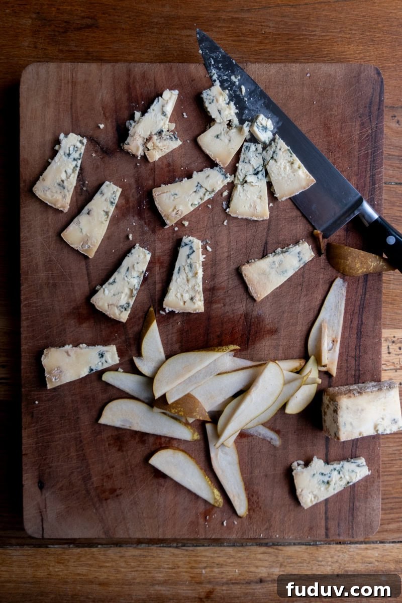 Ginger Nut Canapés with Stilton and Pear 3 Slices of stilton and pear on a chopping board - Georgie Mullen