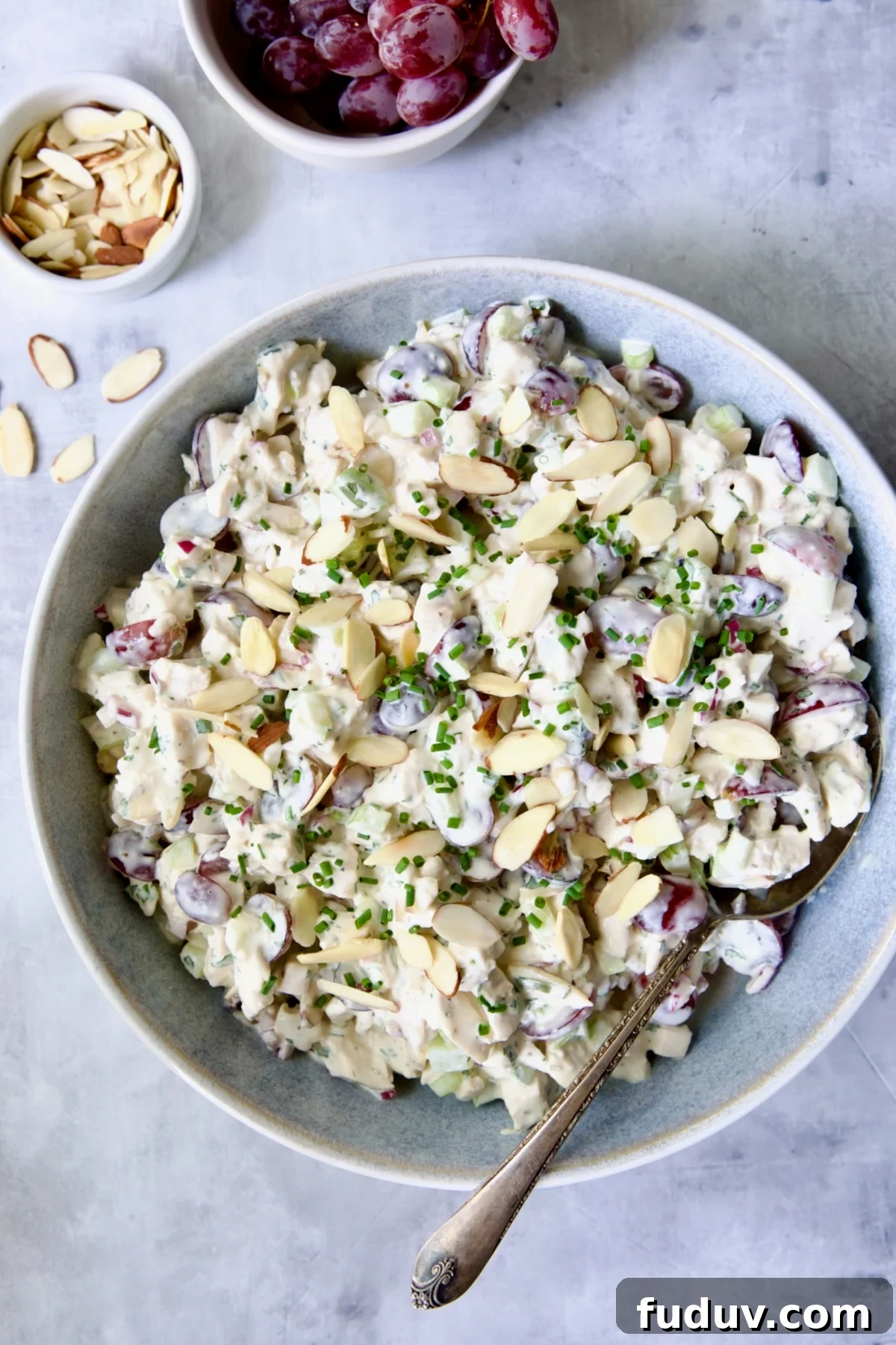 Chicken salad in blue bowl with serving spoon.