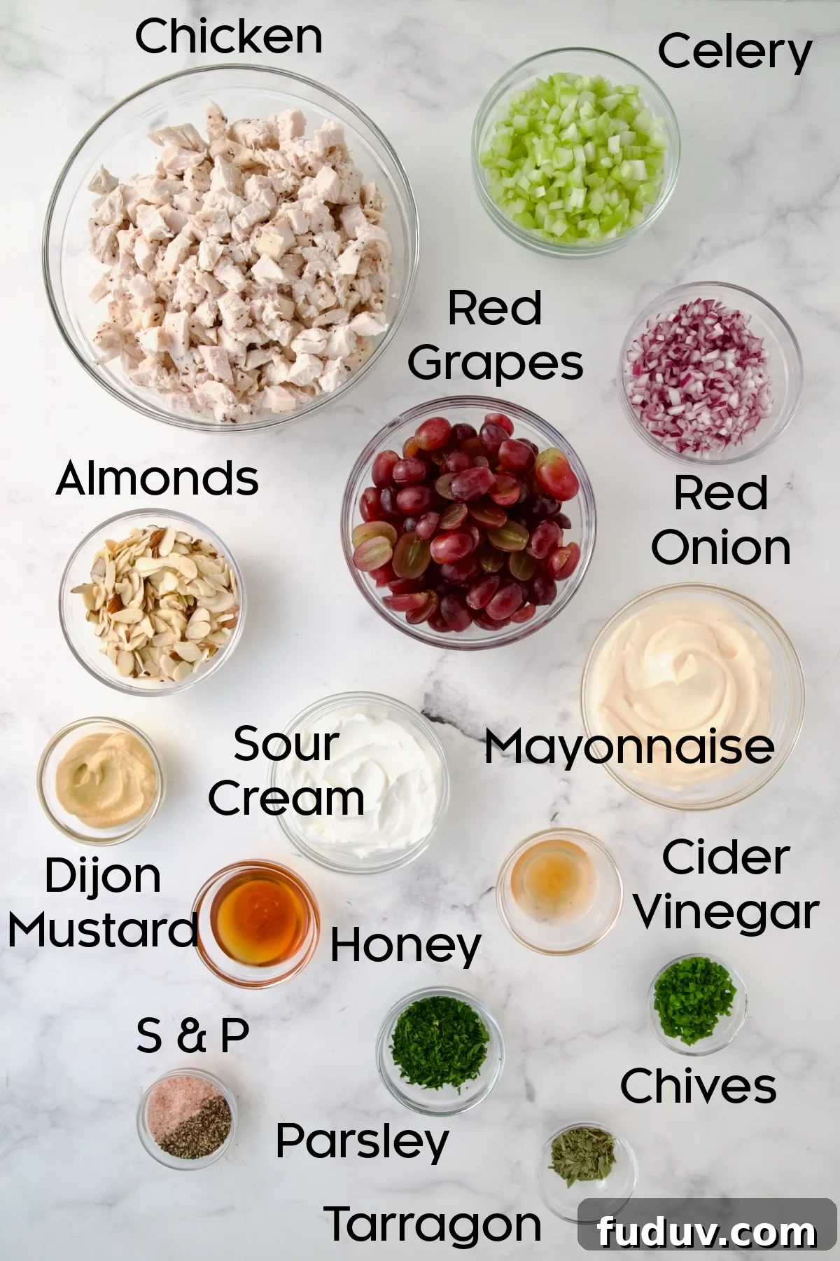 Ingredients for Chicken Salad with Herbs, Almonds and Grapes in glass bowls.