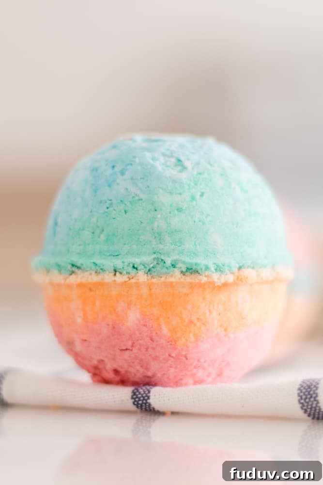 Large multicolor bath bomb for kids on white marble table.