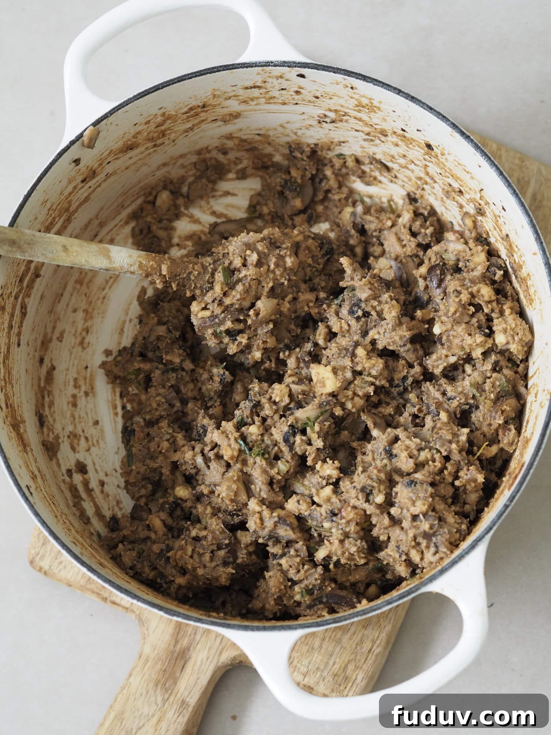 Adding ingredients to a pot for Nut Roast Wellington